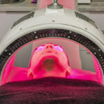 Paciente recibiendo tratamiento facial con luz LED en clínica estética.